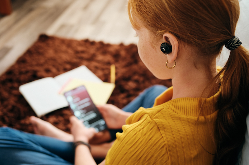 Teenager listening with wireless earphones